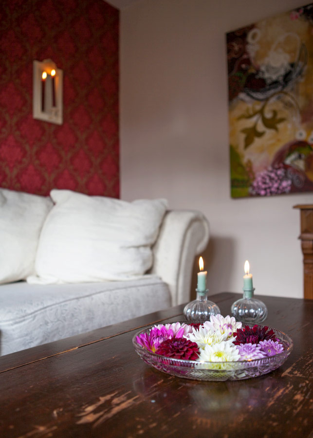Wohnbereich - Rot - Couch - Blumen - Kerzen
